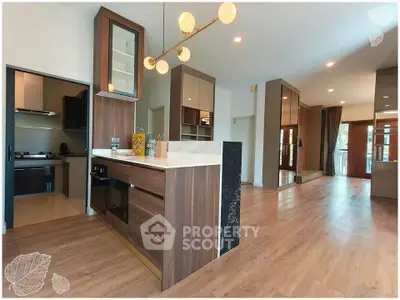 Spacious modern kitchen with elegant wooden cabinetry and open layout in luxury apartment.