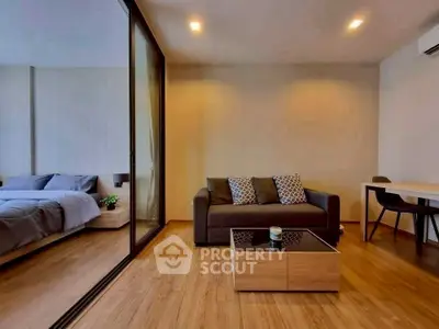 Modern living room with cozy sofa and stylish decor adjacent to a bedroom.