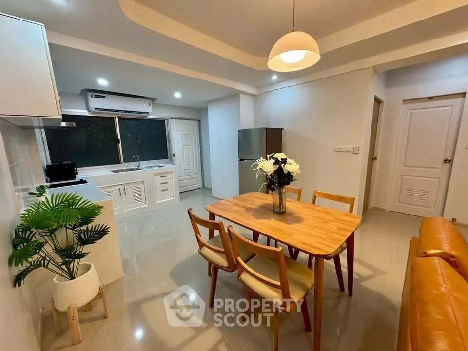 Modern open-layout kitchen and dining area with stylish furniture and ambient lighting.
