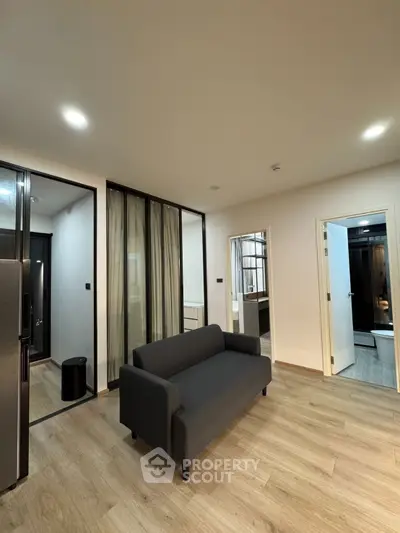 Modern living room with sleek design and stylish furniture, featuring a comfortable sofa and elegant flooring.