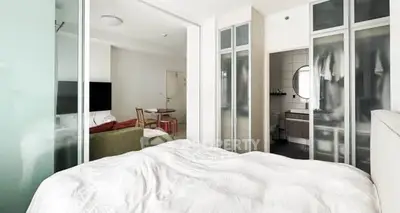 Modern bedroom with frosted glass doors and cozy living area