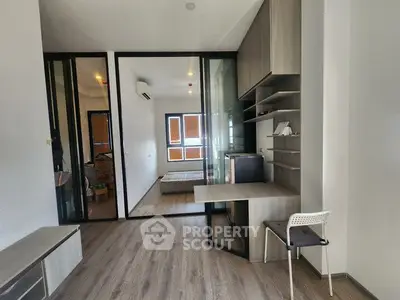Modern apartment interior with study area and bedroom, featuring sleek design and ample natural light.