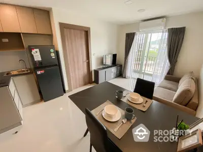 Modern open-plan living room with kitchen, featuring sleek furniture and natural light.