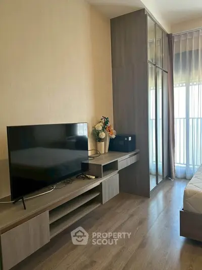 Modern bedroom with sleek TV stand and large window for natural light