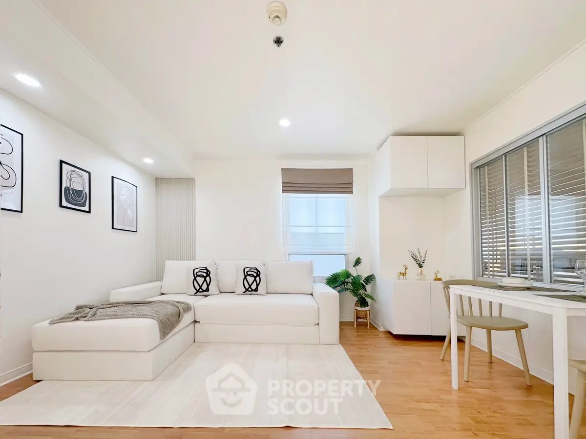 Modern living room with white sofa, wooden floor, and stylish decor