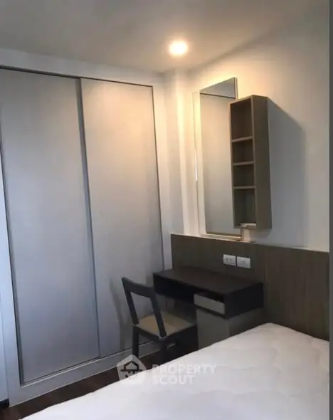 Cozy bedroom with built-in wardrobe and study desk, perfect for modern living.