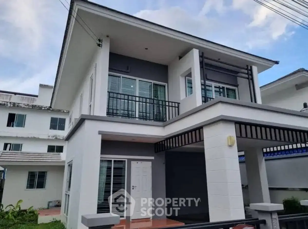 Modern two-story house with sleek design and large windows in a suburban neighborhood.