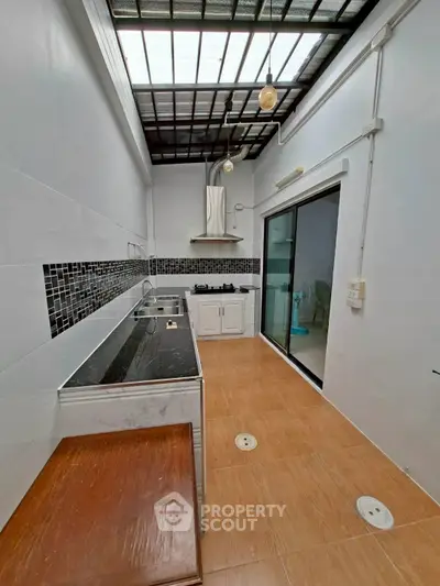 Modern kitchen with sleek design and gas stove, featuring open layout and ample natural light.