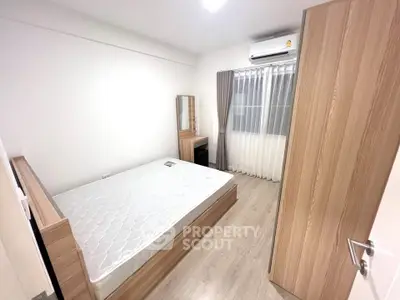 Modern bedroom with wooden furniture and natural light, featuring a comfortable bed and sleek design.