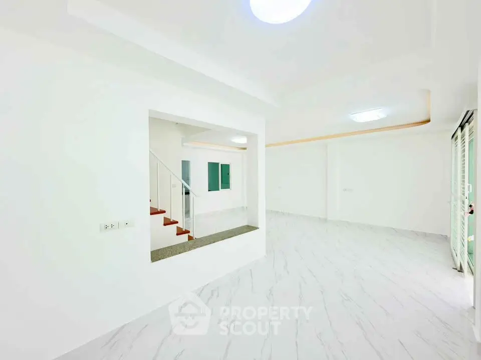 Spacious modern living room with sleek white flooring and open layout design.