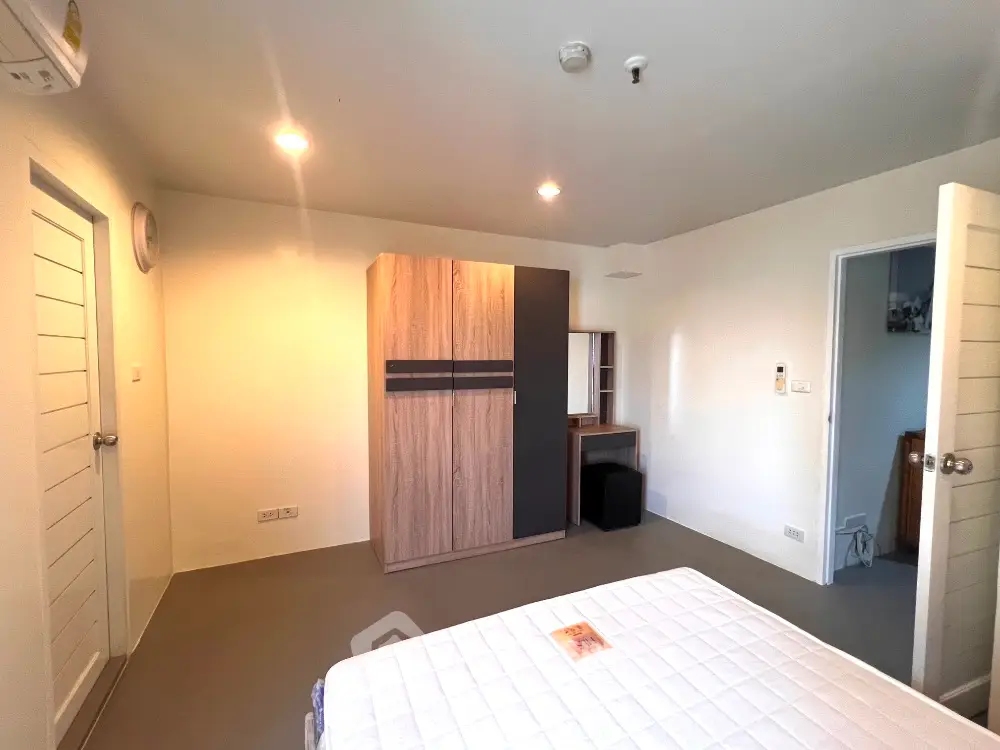 Spacious bedroom with modern wardrobe and cozy lighting in a stylish apartment.