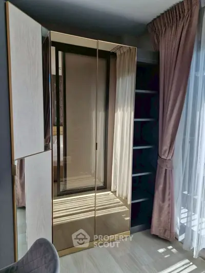 Elegant bedroom corner with mirrored wardrobe and floor-to-ceiling curtains