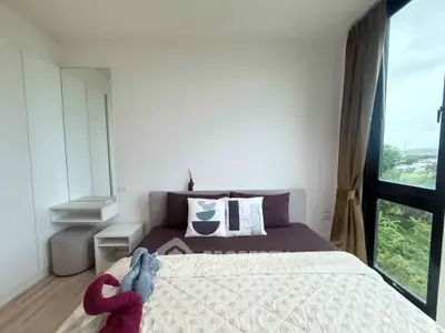 Cozy bedroom with large window and modern decor in a stylish apartment.