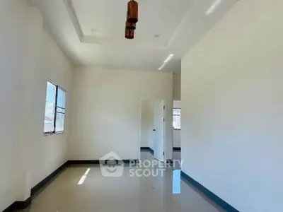 Spacious empty room with high ceiling and natural light