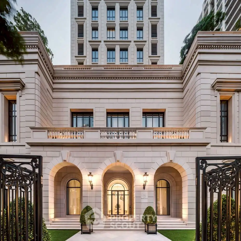 Elegant luxury building entrance with classic architecture and lush greenery, showcasing opulence and sophistication.