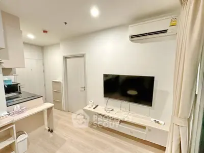Modern living room with wall-mounted TV and air conditioning in a cozy apartment.
