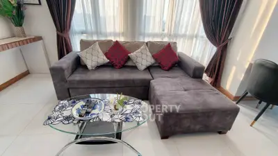 Modern living room with stylish gray sofa and glass coffee table