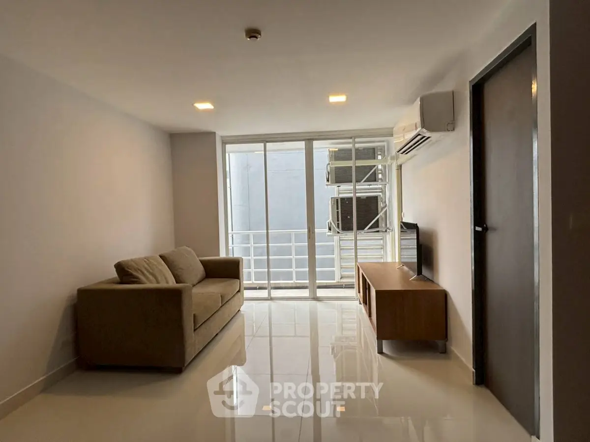 Modern living room with sleek design, featuring a comfortable sofa and large windows for natural light.