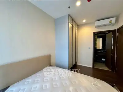 Modern bedroom with built-in wardrobe and air conditioning unit