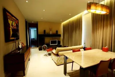 Elegant living room with modern decor and ambient lighting, featuring a cozy seating area and stylish dining table.