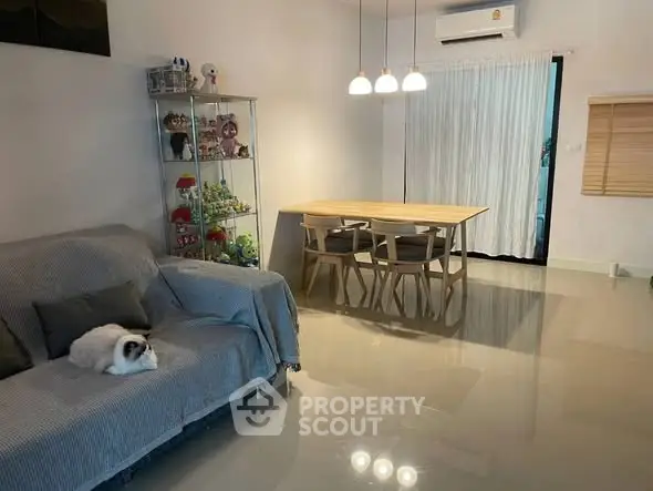 Spacious living room with modern dining area and cozy sofa, perfect for family gatherings.