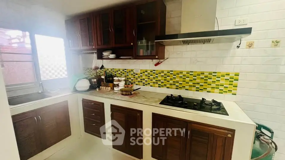 Charming kitchen with gas stove and vibrant backsplash in cozy home