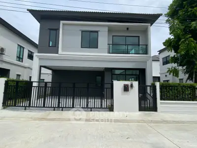 Modern two-story house with sleek design and spacious driveway in a suburban neighborhood.
