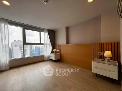Spacious bedroom with city view and modern decor in high-rise apartment