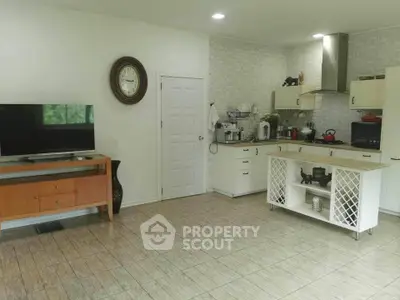 Spacious and modern kitchen with open layout, seamlessly blending into a cozy living area with ample natural light, perfect for entertaining and relaxation.