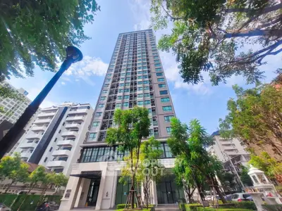 Stunning high-rise building with lush greenery and modern architecture in urban setting.
