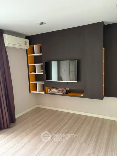 Modern living room with wall-mounted TV and air conditioning unit.