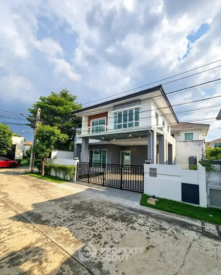 Modern two-story house with sleek design and spacious driveway in a serene neighborhood.