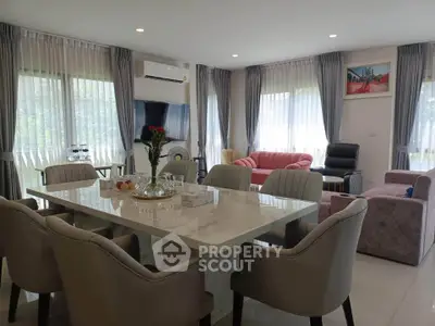 Spacious and elegant living room with modern dining area and cozy seating, perfect for family gatherings.