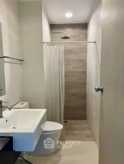 Modern bathroom with sleek design featuring a walk-in shower and contemporary fixtures.