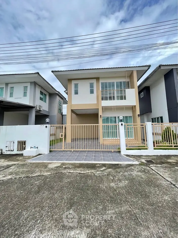 Modern two-story house with sleek design and spacious balcony in a suburban neighborhood.