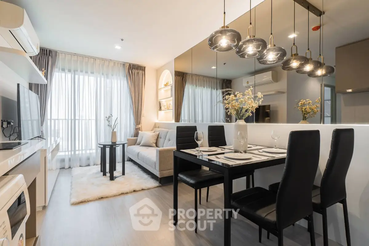 Modern living room with dining area, stylish lighting, and cozy decor in a contemporary apartment.