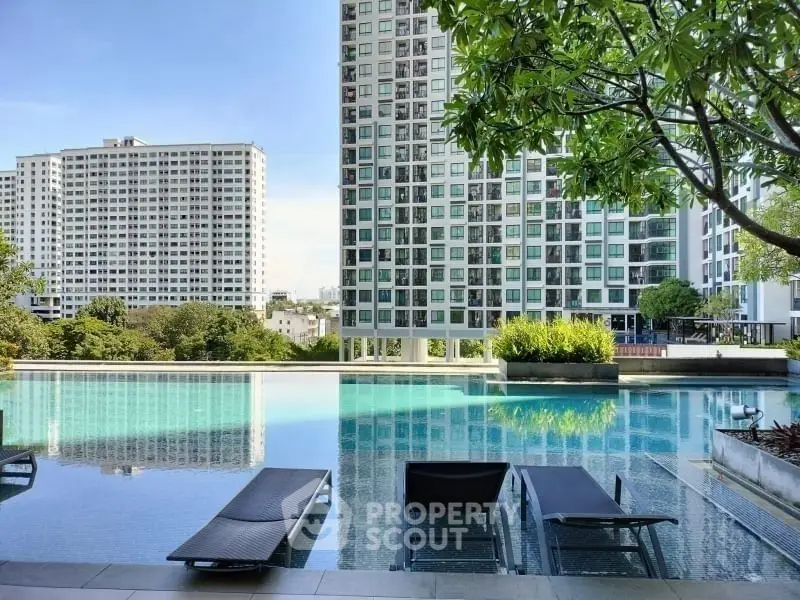 Luxurious poolside view with modern high-rise buildings and lush greenery.