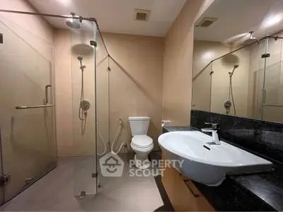 Modern bathroom with glass shower and sleek fixtures in a contemporary apartment.