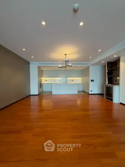 Spacious open-plan living room with modern kitchen and wooden flooring