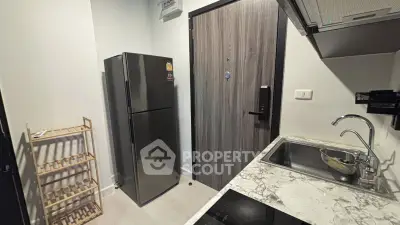 Modern kitchen with sleek appliances and marble countertop in compact layout.