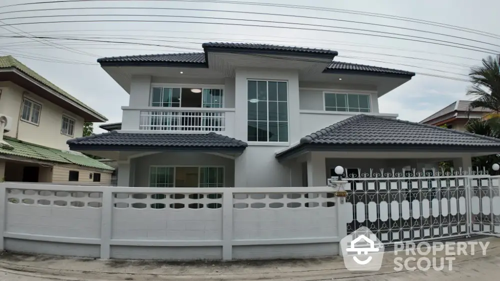 Modern two-story house with sleek design and spacious balcony in suburban neighborhood.