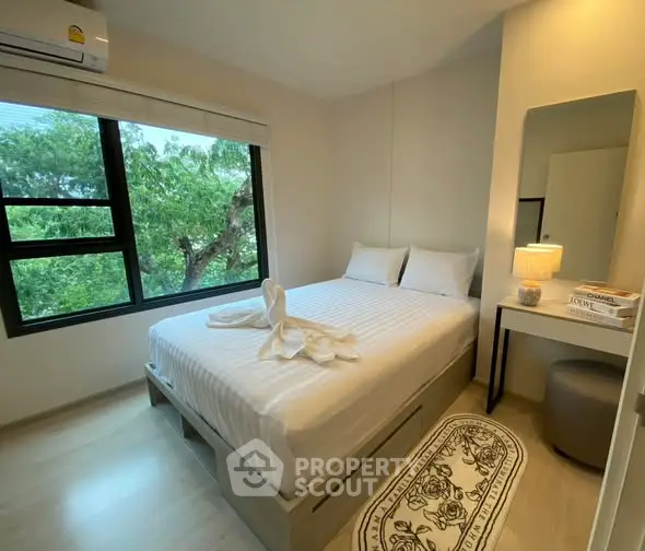 Cozy bedroom with large window and modern decor, perfect for relaxation and comfort.