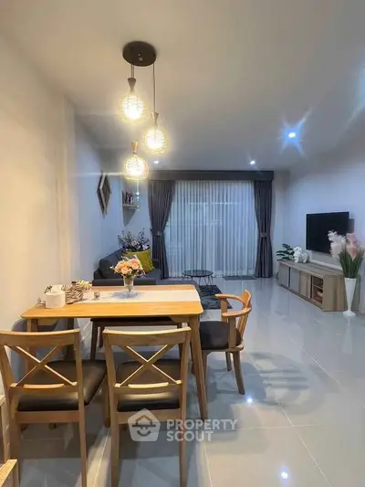 Modern living room with dining area, stylish lighting, and elegant decor.