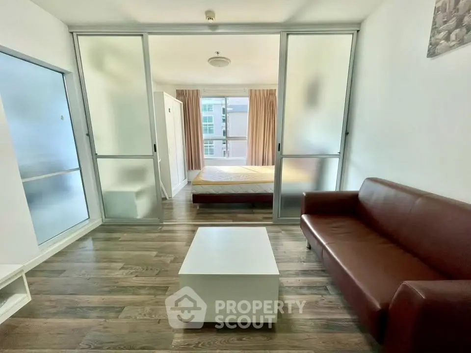 Modern studio apartment with sliding glass doors and wooden flooring