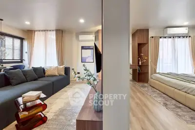 Modern open-plan living room and bedroom with stylish decor and natural light.