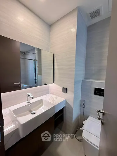 Modern bathroom with sleek design, featuring a stylish sink and contemporary fixtures.