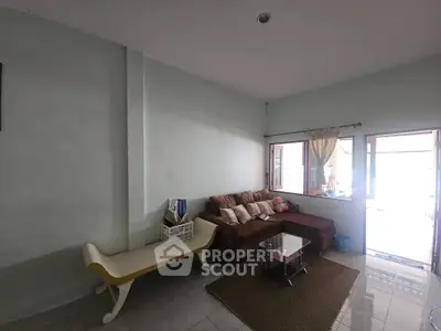 Cozy living room with sectional sofa and natural light from large windows.