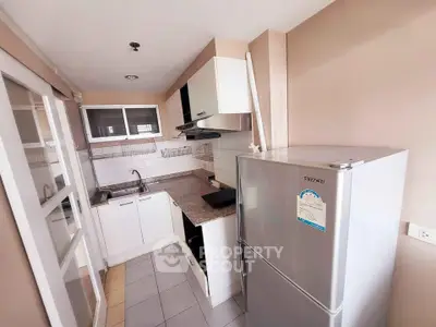 Modern compact kitchen with sleek appliances and ample storage in a cozy apartment.