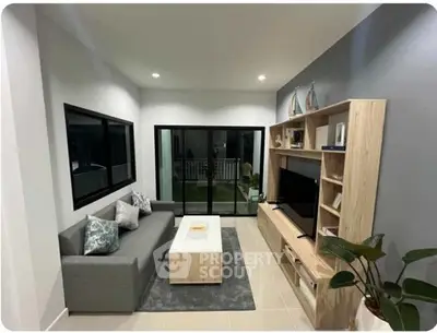 Modern living room with sleek furniture and large windows offering a cozy ambiance.