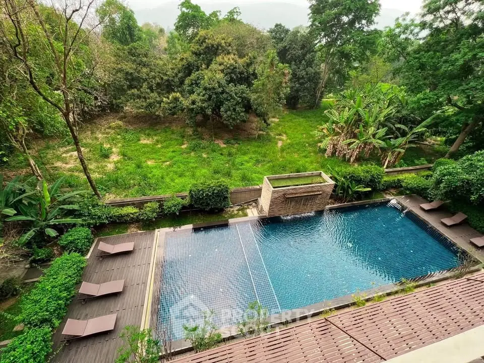 Luxurious outdoor pool with lush greenery and serene surroundings, perfect for relaxation and leisure.